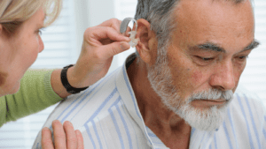 Man fits a hearing aid