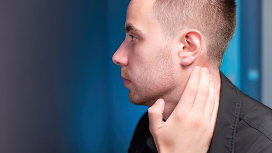 Man touching the area behind his ear, representing ear cleaning tool safety